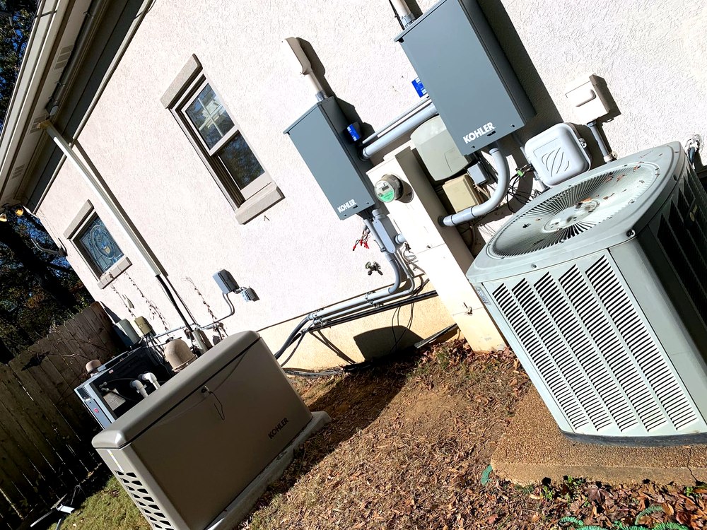 Kohler standby generator and automatic transfer switch installed beside an AC condenser