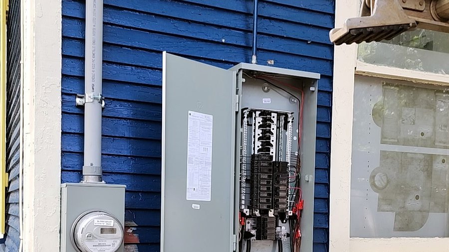 Open residential electrical panel with breakers, recently serviced