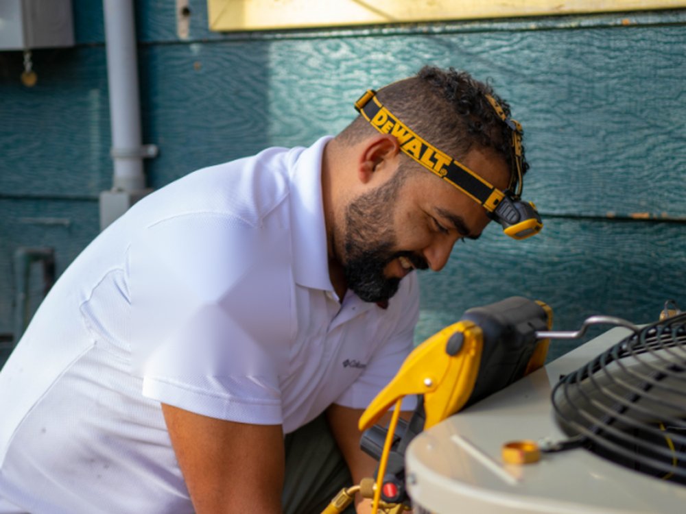 Memphis HVAC Plus technician servicing an outdoor AC condenser unit
