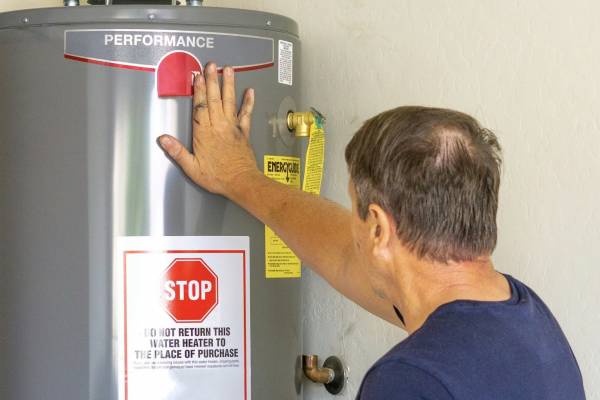 Adult male with hand on newly installed hot water heater